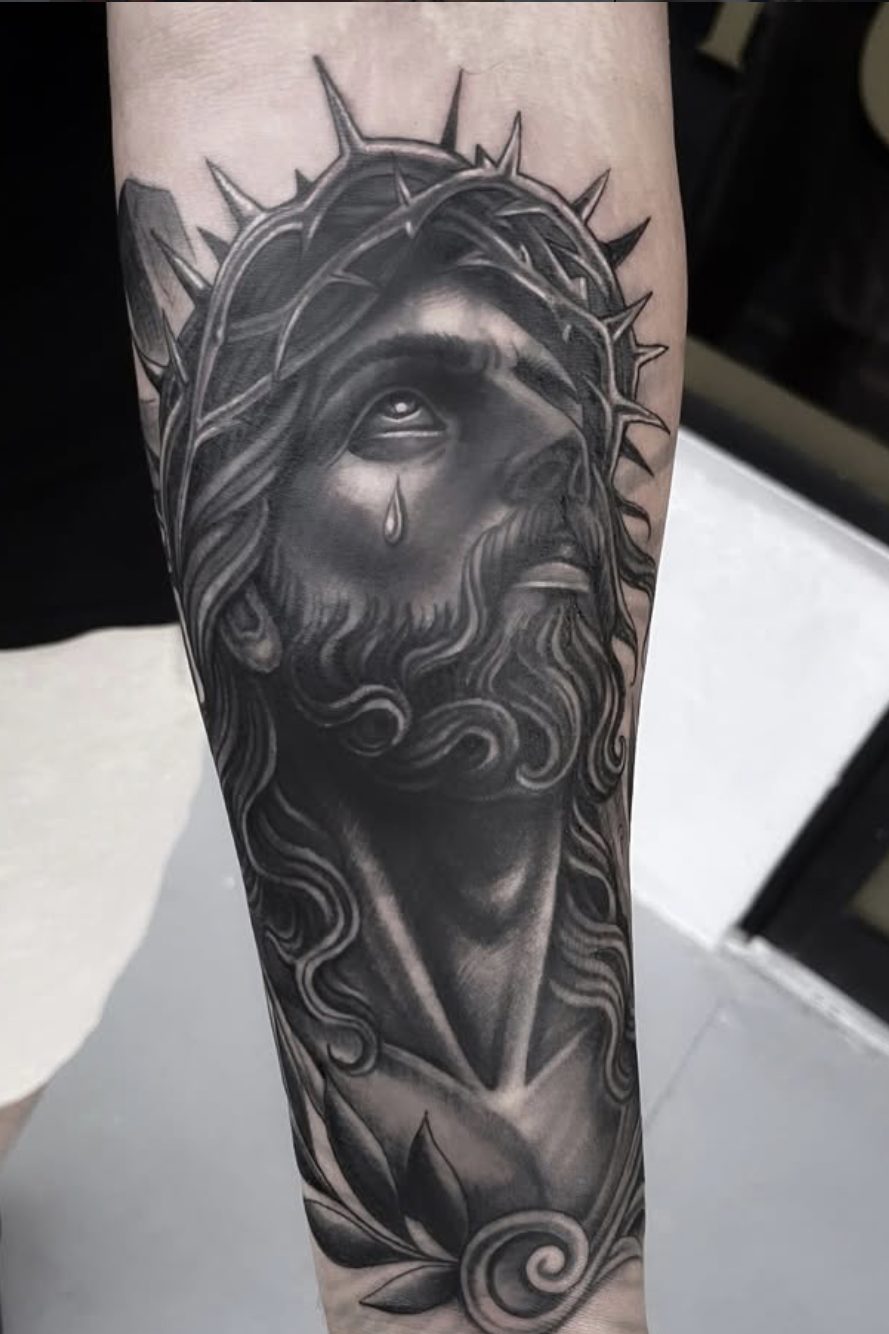 Black and gray Jesus with crown of thorns forearm tattoo by Danny Mac
