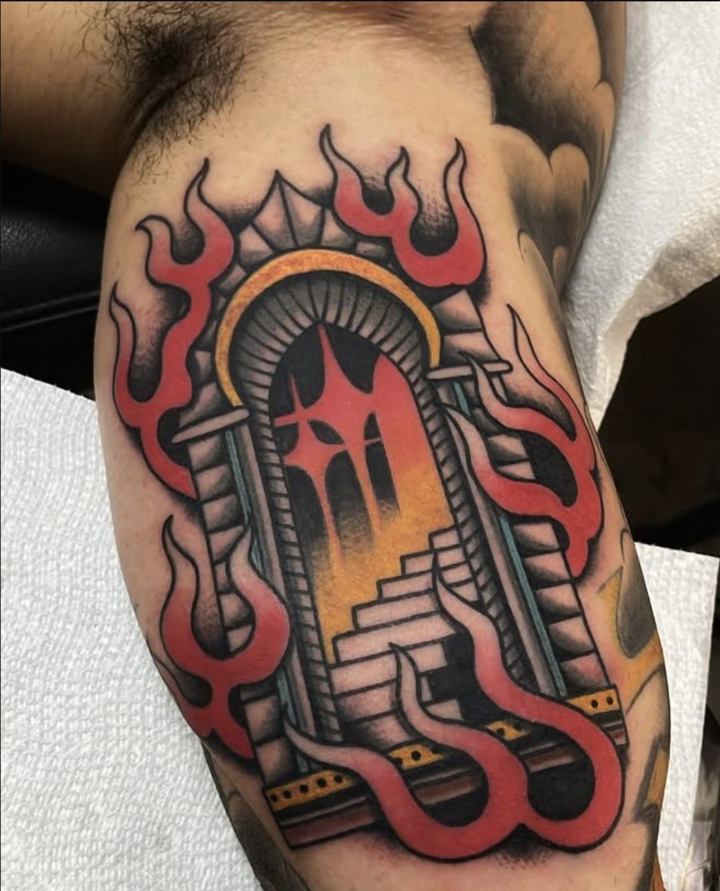 Traditional burning doorway tattoo on inner arm by Danny Mac