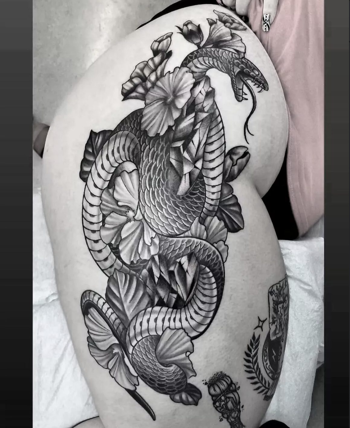 Black and gray snake and flowers hip and thigh tattoo by Danny Mac