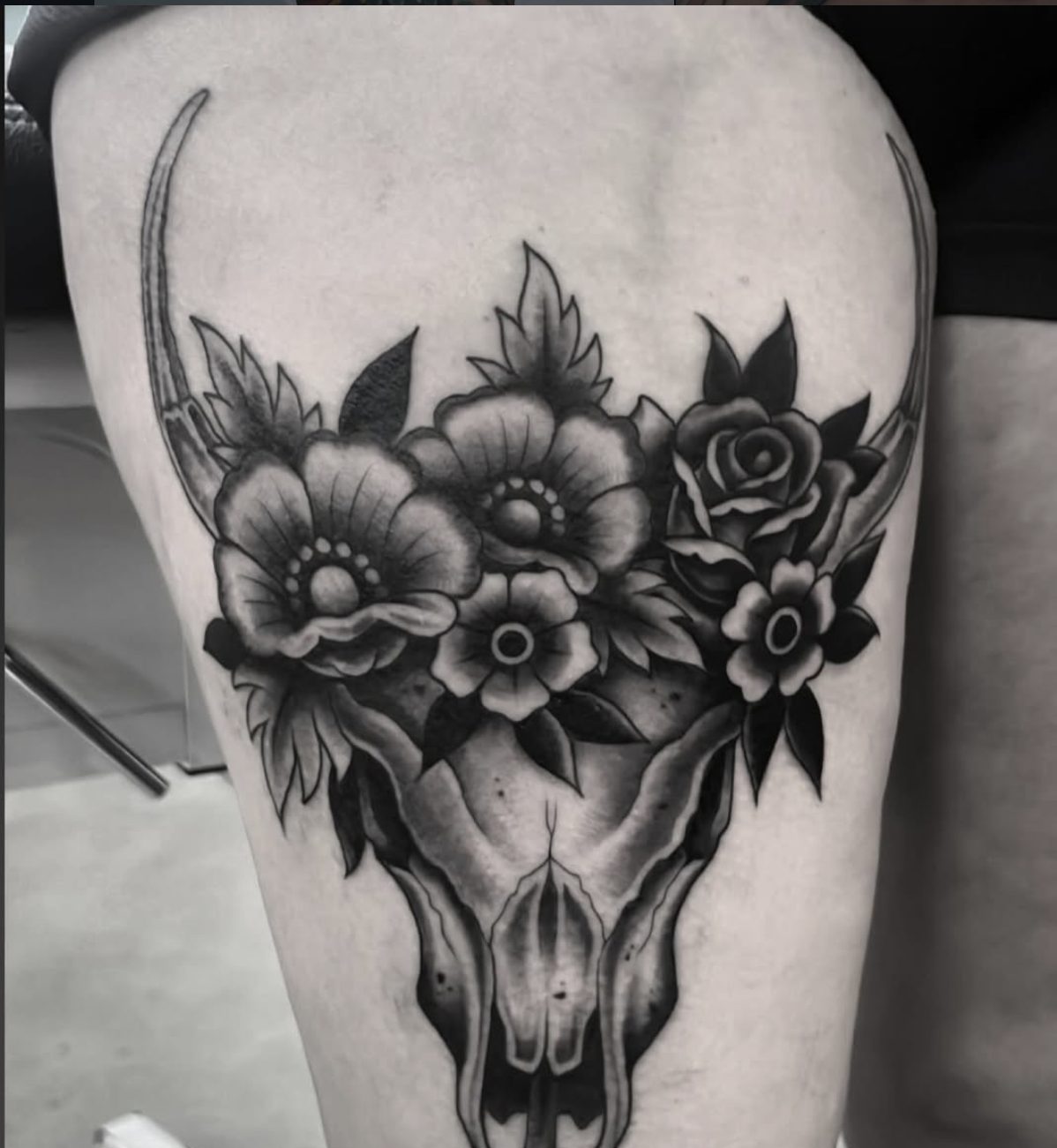Black and gray bull skull with flowers thigh tattoo by Danny Mac