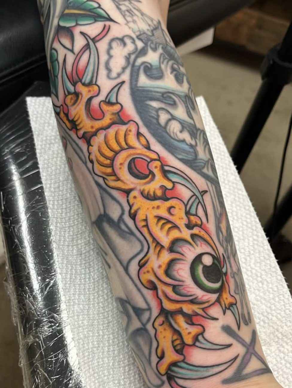 Color eyeball and bones filler tattoo by Danny Mac